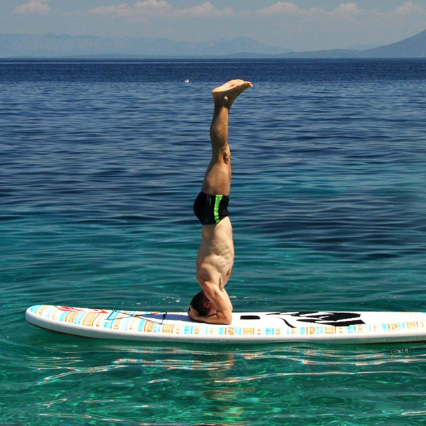 Hraní na jógu. Super zábava na paddleboardu u moře.